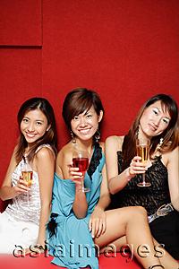 Asia Images Group - Young women, holding drinks and smiling at camera