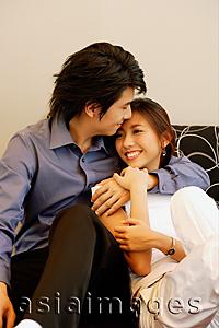 Asia Images Group - Man with arm around woman, kissing her forehead
