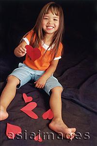 Asia Images Group - Young girl holding paper hearts, looking at camera