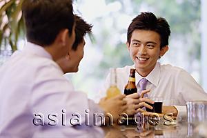 Asia Images Group - Young men at bar counter with drinks