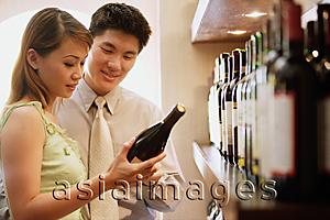 Asia Images Group - Couple reading label on wine bottle