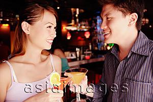 Asia Images Group - Couple standing and holding drinks