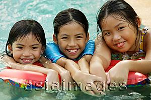 Asia Images Group - Three girls in swimming pool, looking at camera