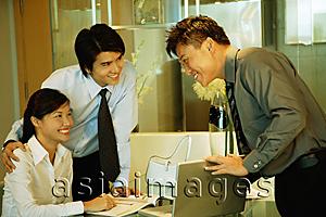 Asia Images Group - Businessman showing laptop to couple in front of him