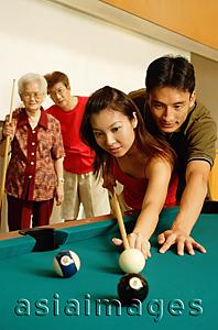 Asia Images Group - Couple playing pool, father and grandmother looking on