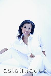 Asia Images Group - Woman in white shirt and pants, sitting and looking at camera