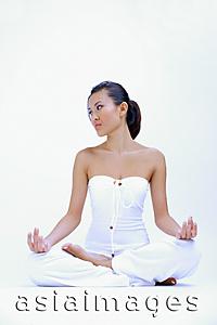 Asia Images Group - Woman dressed in white, sitting with legs crossed