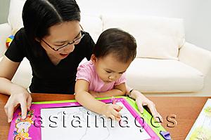 Asia Images Group - Mother watching daughter draw