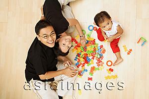 Asia Images Group - Family with one child sitting on floor looking at camera