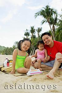 Asia Images Group -  Father with two children on beach, looking at camera