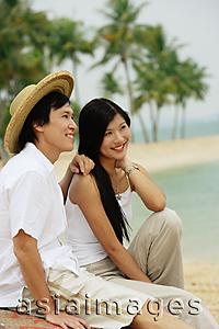 Asia Images Group - Couple sitting on beach, looking away