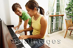 Asia Images Group - Mother and daughter at home, playing on piano