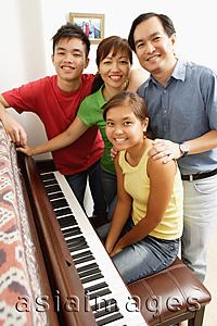 Asia Images Group - Family with two children, standing around piano, portrait