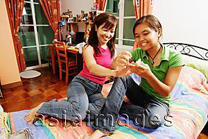 Asia Images Group - Daughter applying nail polish on mother's nails