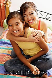 Asia Images Group - Mother hugging daughter, both smiling, looking at camera