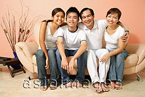 Asia Images Group - Family of four in living room, looking at camera, portrait