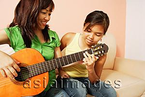 Asia Images Group - Mother and daughter side by side, mother holding guitar