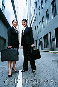 Asia Images Group - Business women standing side by side looking at camera, portrait