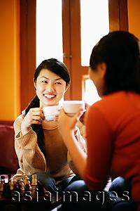 Asia Images Group - Two young women having tea