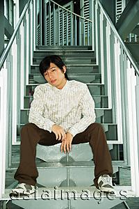 Asia Images Group - Young man sitting on steps, looking at camera