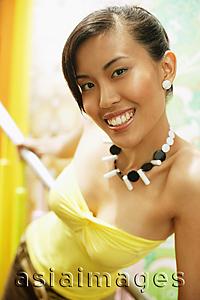 Asia Images Group - Young woman, holding on to railing, looking at camera