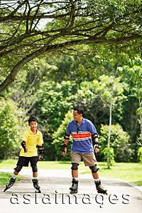 Asia Images Group - Father and son in park, on roller blades