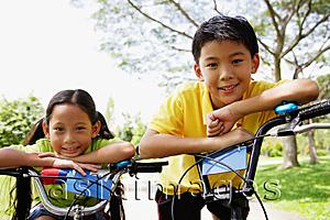 Asia Images Group - Brother and sister on bicycles, looking at camera