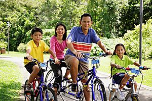 Asia Images Group - Family on bicycles, looking at camera