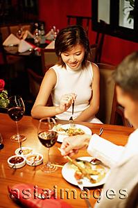 Asia Images Group - Couple at restaurant, eating, over the shoulder view