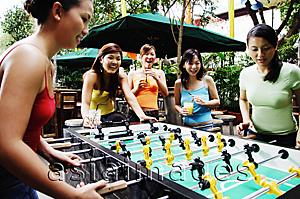 Asia Images Group - Young women playing foosball
