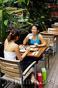 Asia Images Group - Young women at cafe, eating and drinking