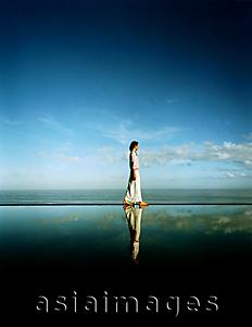 Asia Images Group - Asian female walking along edge of horizon pool