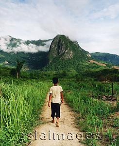 Asia Images Group - Laotian guide walking along country path in hilltribe country