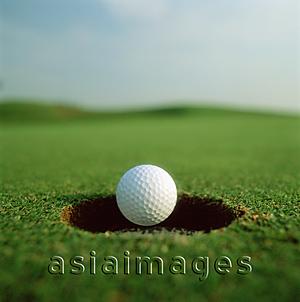 Asia Images Group - Golf ball dropping in to hole