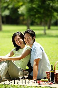 Asia Images Group - Couple having picnic in park, looking at camera