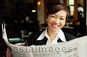 Asia Images Group - Businesswoman holding newspaper, smiling