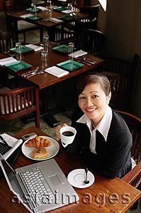 Asia Images Group - Businesswoman holding cup, smiling at camera