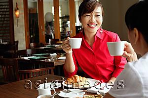 Asia Images Group - Two women having tea at cafe, over the shoulder view