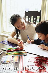Asia Images Group - Mother sitting with son, drawing with colour pencils