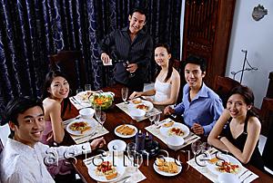 Asia Images Group - Adults at a dinner party, sitting around table, smiling at camera