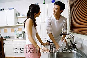 Asia Images Group - Couple in kitchen, washing dishes