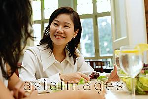 Asia Images Group - Woman in restaurant smiling at person next to her