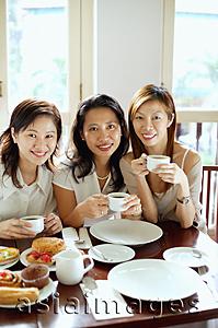 Asia Images Group - Three women smiling at camera, holding cups, portrait