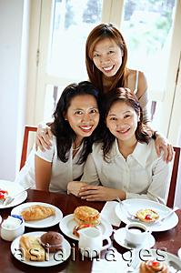 Asia Images Group - Three women in cafe, smiling at camera, portrait