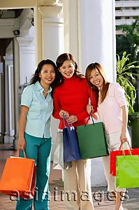 Asia Images Group - Three women with shopping bags, smiling at camera