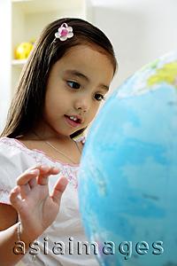 Asia Images Group - Young girl looking at globe
