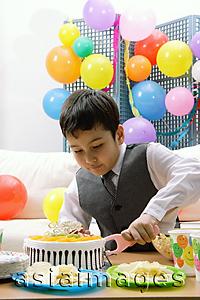 Asia Images Group - Boy cutting birthday cake