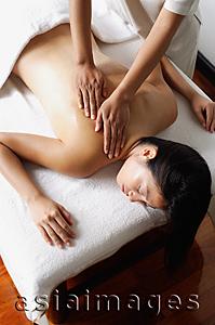 Asia Images Group - Woman lying on massage table being massaged