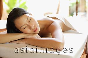 Asia Images Group - Woman lying on massage table, leaning head on arms