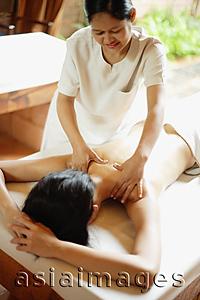Asia Images Group - Woman on massage table being massaged by masseuse